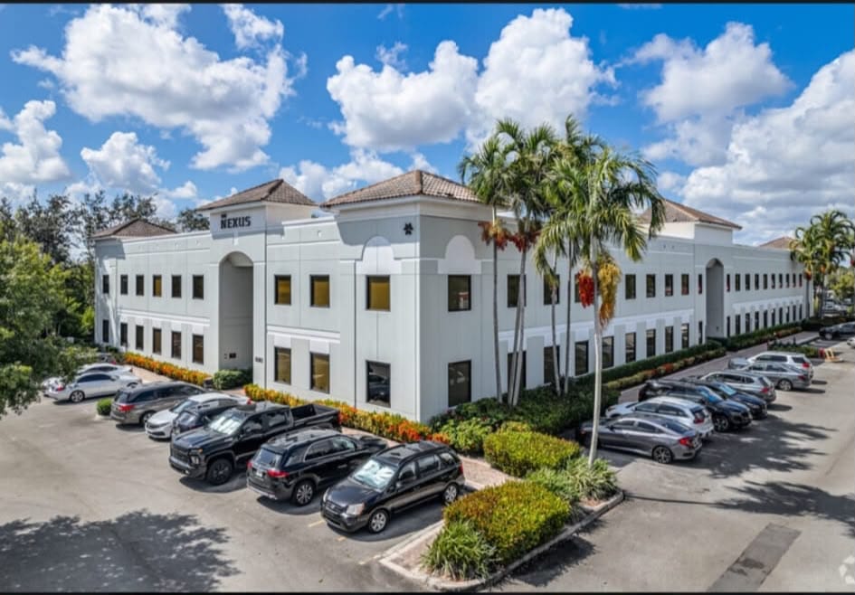 The Palm Beach office, a white two-story building with a tile roof and palm trees.